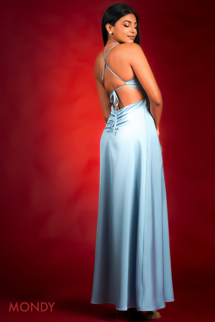 Woman in a light blue dress with thin straps against a red background